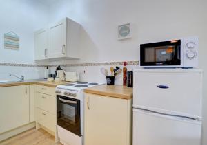 a kitchen with a white refrigerator and a microwave at Barn 2 - Cow in Ystradgynlais