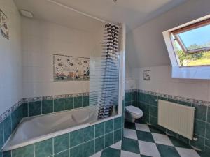 a bathroom with a tub and a toilet and a window at Stone House in Brittany near Morlaix Bay in Plouégat-Guérand +13 photos