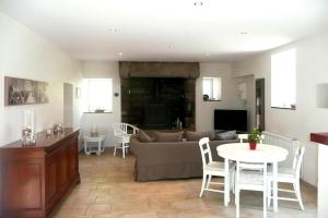 ein Wohnzimmer mit einem Sofa und einem Tisch in der Unterkunft Holiday Home Plouégat-Guérand - BRE05042-F in Plouégat-Guérand