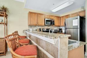 a kitchen with a sink and a refrigerator at Palms of Treasure Island 208 in St. Pete Beach