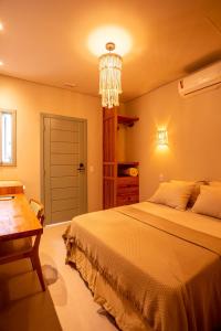 a bedroom with a large bed and a chandelier at Casa Savana in São Paulo