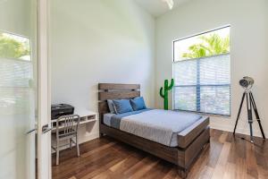 Un dormitorio con una cama y un escritorio y dos ventanas. en Villa Aviator, en Cabo Coral 12 fotos más