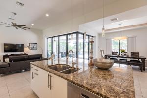 Una cocina con fregadero y una sala de estar. en Villa Aviator, en Cabo Coral