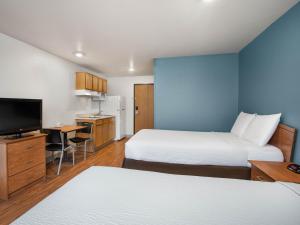 Una habitación de hotel con dos camas y un televisor de pantalla plana. en Extended Stay America Select Suites - Charleston - Ashley Phosphate Rd, en Hanahan