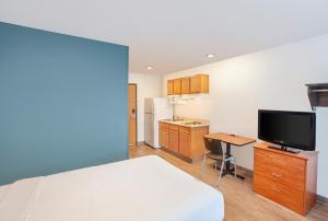 sypialnia z łóżkiem i biurkiem z telewizorem w obiekcie Extended Stay America Select Suites - Phoenix - Peoria - Sun City w mieście Peoria