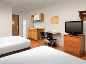a hotel room with two beds and a flat screen tv at Extended Stay America Select Suites - Cincinnati - Florence - Airport in Florence