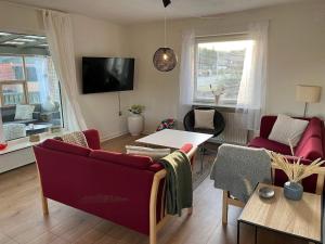 salon z czerwoną kanapą i stołem w obiekcie Holiday home Hvide Sande CXIV w mieście Hvide Sande