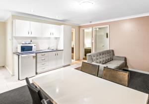 a living room with a table and a kitchen at Villa Nova Motel in Toowoomba