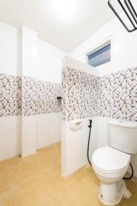 La salle de bains est pourvue de toilettes et d'une fenêtre. dans l'établissement Amaz Villa, à Ban Nang Lae