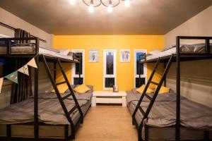 two bunk beds in a room with yellow walls at Amaz Villa in Ban Nang Lae