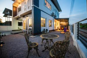 a patio with a table and chairs and a house at Amaz Villa in Ban Nang Lae