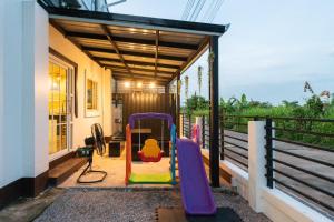 een huis met een glijbaan op de veranda bij Amaz Villa in Ban Nang Lae