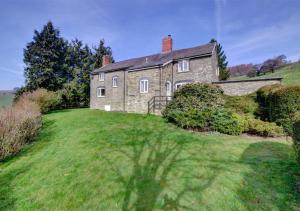 an old stone house on a grassy hill at Black Patch in Norton