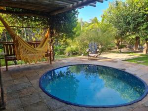 un patio con una hamaca y una piscina en Chalés Refúgio Fortim en Fortim