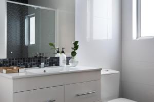 a white bathroom with a sink and a mirror at Haven in Daylesford +13 photos
