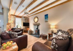 sala de estar con muebles de cuero y chimenea en Bryn Tirion, en Llanbedrog