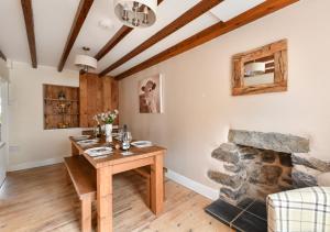a dining room with a table and a fireplace at Bryn Tirion in Llanbedrog