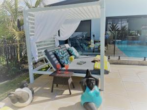 a house with two people laying on the ground next to a pool at Mulwala Resort in Mulwala