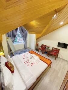een slaapkamer met een groot bed met rode bloemen erop bij Moc Nhien Hostel Da Lat in Da Lat