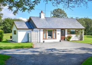 a white house with a driveway at Bryn Penmaen in Pwllheli