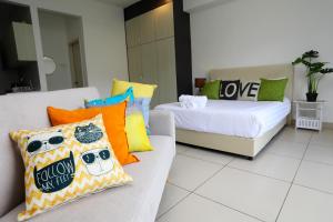 een woonkamer met 2 bedden en een bank met kussens bij LOVELY & COZY HOME @ MIDILLS GENTING in Genting Highlands +24 foto's