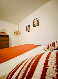 德豪特漁村的住宿－Ti karet - Charmant logement avec Jacuzzi et vue mer，卧室内的一张床铺,墙上有两张照片
