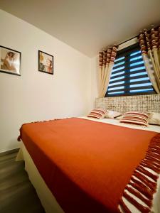 ein Schlafzimmer mit einem großen orangenen Bett und einem Fenster in der Unterkunft Ti karet - Charmant logement avec Jacuzzi et vue mer in Terre-de-Haut