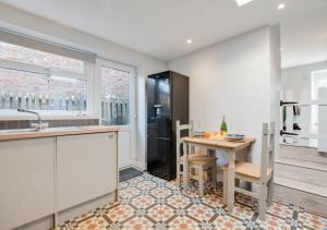 a kitchen with a table and a sink at Bwthyn Bach in Ferryside