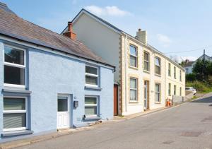 una fila de casas azules y blancas en una calle en Bwthyn Bach, en Ferryside