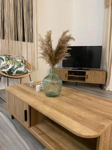 豪特尔Ti karet - Charmant logement avec Jacuzzi et vue mer的客厅咖啡桌上的花瓶
