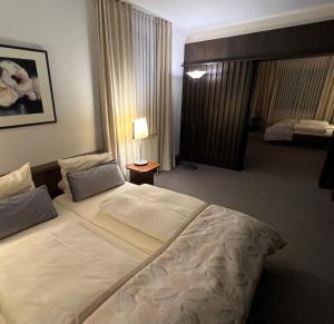 ミンデンにあるHotel Exquisitの大きなベッドとランプが備わるホテルルームです。