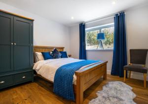 Parkmill的住宿－Bryn Y Mor，一间卧室配有一张带蓝色窗帘的床和一把椅子