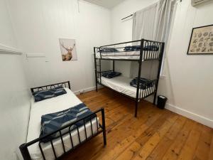 two bunk beds in a room with a wooden floor at Gonow Family Backpackers Hostel in Brisbane