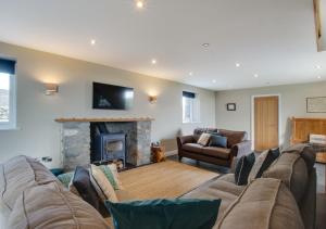 uma sala de estar com um sofá e uma lareira em Bwthyn Ednyfed em Criccieth