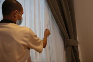 a man wearing a mask looking through a curtain at المهيدب للوحدات السكنيه - البوادي in Jeddah