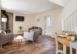 a living room with a table and chairs at Bwthyn Clyd in Llanddyfnan