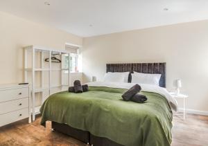 a bedroom with a large bed with two pillows on it at Bwthyn Clyd in Llanddyfnan