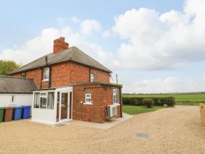 an old brick house on a gravel driveway at 2 Lane End Cottages in Hull