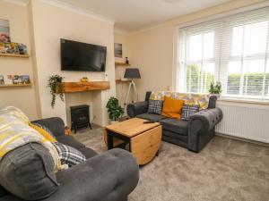 un soggiorno con due divani e una TV di 2 Lane End Cottages a Hull
