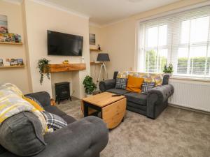 a living room with two couches and a tv at 2 Lane End Cottages in Hull