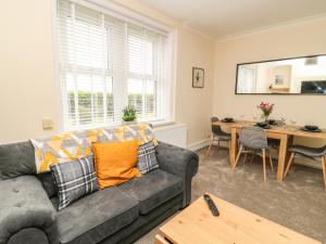 a living room with a couch and a table at 2 Lane End Cottages in Hull