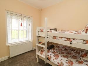 1 dormitorio con 2 literas y ventana en 2 Lane End Cottages en Hull