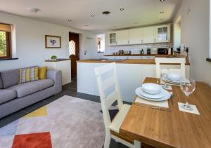 a kitchen and living room with a table and a couch at Caeau Bach in Bottwnog