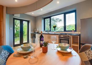 a kitchen with a wooden table with two wine glasses at Caban Silo in Henfynyw Upper