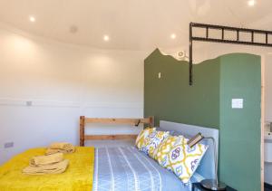 a bedroom with a bed with a yellow blanket at Caban Silo in Henfynyw Upper