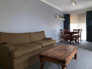 a living room with a couch and a wooden table at Portarlington Holiday Apartment in Portarlington