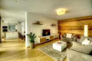 a living room with a couch and a tv at dasLichtenberg westside in Saalfelden am Steinernen Meer