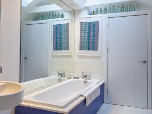 a white bathroom with a tub and a sink at Tigh Nam Muc in Loanhead