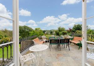 un patio con sillas y mesas y vistas al campo en Clynderwen House en Pembroke