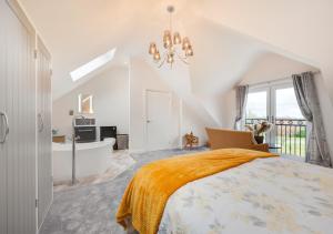 a bedroom with a large bed and a bathroom at Cluniac Cottage in Menai Bridge